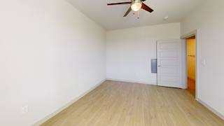 A room with a ceiling fan and wooden flooring. at ThreeTwenty at the Vybe Apartments, Kyle, 78640