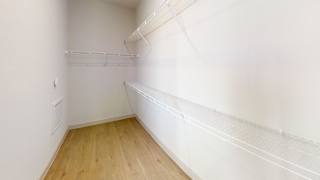 A white wall with a wooden floor and a white shelf. at ThreeTwenty at the Vybe Apartments, Kyle