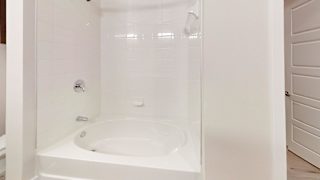 a white bathroom with a shower and a sink at Bridge at Speyside Apartments, Austin, 78754