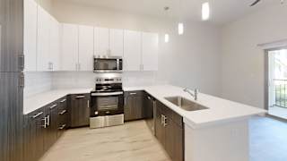 a large kitchen with white counter tops and wooden cabinets at Bridge at Speyside Apartments, Austin, TX, 78754