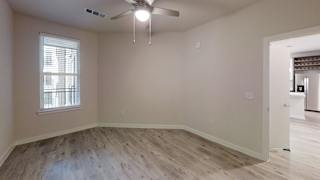 Empty bedroom with ceiling fan and window at Bridge at Windsor Park Apartments, Austin, 78723