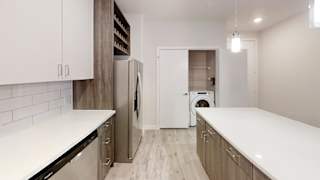 Modern kitchen with island and laundry closet at Bridge at Windsor Park Apartments, Austin, Texas