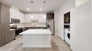 Modern kitchen with white island and stainless appliances at Bridge at Windsor Park Apartments, Austin