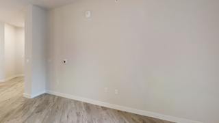 Empty room with white walls and wood flooring at Bridge at Windsor Park Apartments, Texas