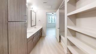 A spacious bathroom with a walk-in shower and a vanity with a mirror.