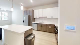 A modern kitchen with white countertops and brown cabinets.