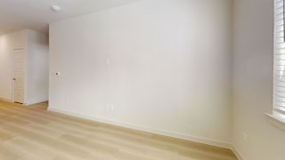 A room with a white wall and a wooden floor.