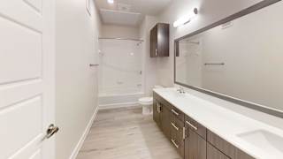 a bathroom with a shower and a sink and a mirror at Bridge at Speyside Apartments, Austin, TX, 78754
