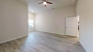 an empty living room with white walls and a ceiling fan at Bridge at Speyside Apartments, Austin, 78754