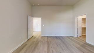 an empty living room with white walls and wood floors at Bridge at Speyside Apartments, Austin, 78754