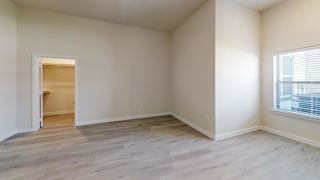 an empty living room with wood flooring and a window at Bridge at Speyside Apartments, Austin, Texas
