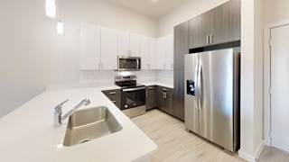 a kitchen with stainless steel appliances and white counter tops at Bridge at Speyside Apartments, Austin