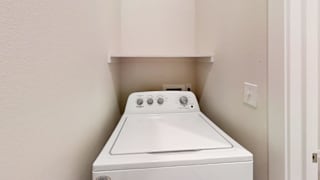 a washer and dryer in an empty laundry room with white walls and a at Bridge at Speyside Apartments, Austin, TX, 78754