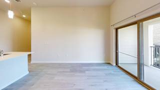 an empty living room with sliding glass doors to a balcony at Bridge at Speyside Apartments, Texas, 78754