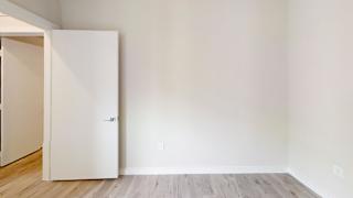 Empty room with wood flooring and open door at Bridge at Windsor Park Apartments, Austin, 78723