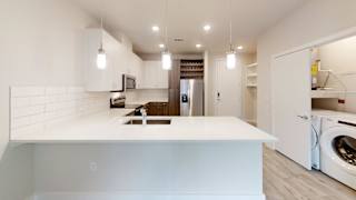 Open kitchen with white countertops and pendant lighting at Bridge at Windsor Park Apartments, Texas, 78723