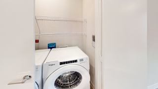 Laundry closet with front load washer and shelving at Bridge at Windsor Park Apartments, Austin, TX 78723