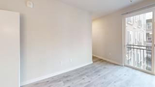 Empty room with balcony and light wood floors at Bridge at Windsor Park Apartments, Austin, TX