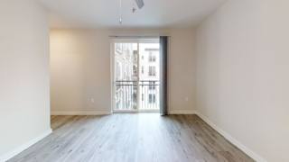 Empty living room with balcony access at Bridge at Windsor Park Apartments, Austin, 78723