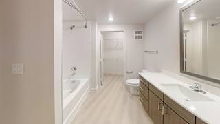 A white bathroom with a tub, toilet, and sink.