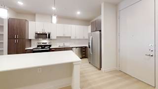 A kitchen with white countertops and a refrigerator.