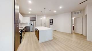 A modern kitchen with a white island in the middle.
