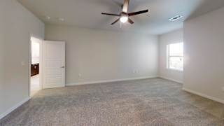 an empty living room with a ceiling fan and a door to a bathroom at Bridge at Speyside Apartments, Austin, TX, 78754