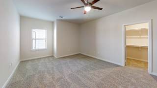 an empty living room with a ceiling fan and a closet at Bridge at Speyside Apartments, Austin, 78754