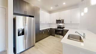 a modern kitchen with stainless steel appliances and white counter tops at Bridge at Speyside Apartments, Austin, TX, 78754