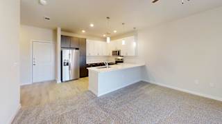 an open kitchen and living room with a white counter top at Bridge at Speyside Apartments, Austin, TX, 78754