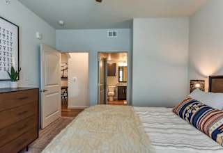 Bedroom with ensuite bathroom and hardwood flooring at High Point Preserve Apartments, Texas
