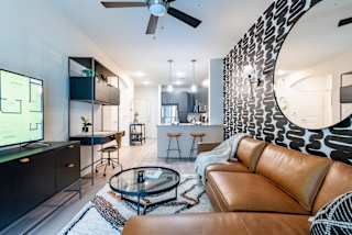 a living room with a brown leather couch and a glass coffee table at Avery Ranch, Austin