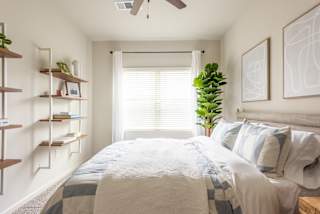 a bedroom with white walls and a white bed with a blue and white comforter at Avery Ranch, Austin, 78717
