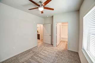 a bedroom with a ceiling fan and a doorway to a bathroom at Avery Ranch, Austin, 78717