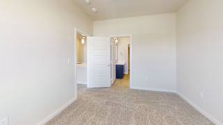 a bedroom with white walls and carpet and a door to a bathroom at Bridge at Speyside Apartments, Texas, 78754