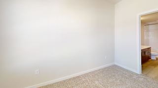 an empty room with white walls and a bathroom at Bridge at Speyside Apartments, Austin, TX, 78754