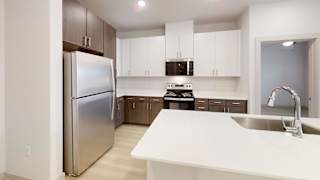 A modern kitchen with a stainless steel refrigerator and white countertops. at Bridge at Saffron Apartments, Texas, 78717