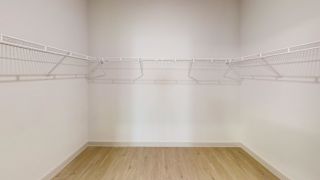 Empty room with white walls and wooden floor. at ThreeTwenty at the Vybe Apartments, Kyle, Texas