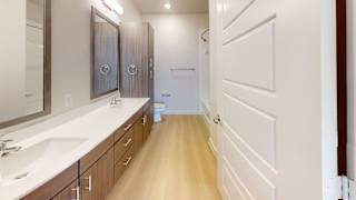A bathroom with a sink, mirror, and wooden cabinets.