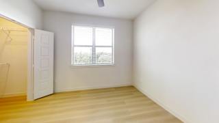 A room with a window and a wooden floor.
