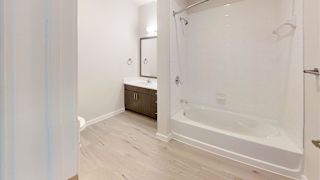 A white bathroom with a tub and sink. at Bridge at Speyside Apartments, Austin, TX, 78754