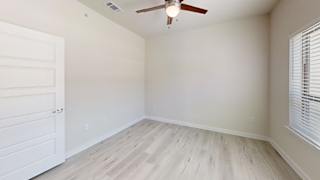 A room with a ceiling fan and a white door. at Bridge at Speyside Apartments, Texas