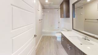A white bathroom with a toilet, sink, and mirror. at Bridge at Speyside Apartments, Austin, TX, 78754