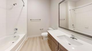 A white bathroom with a tub, toilet and sink.