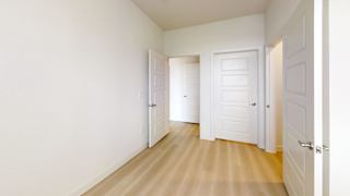 A hallway with white doors and wooden floors.