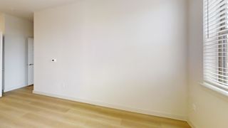 A room with a white wall and wooden floor.