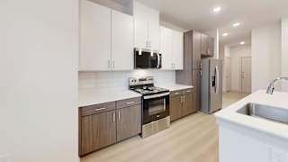 A modern kitchen with wooden cabinets and stainless steel appliances. at Bridge at Saffron Apartments, Texas