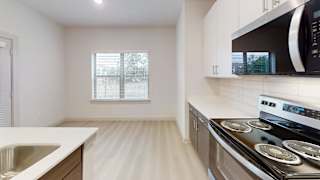 A kitchen with a stove, microwave, and sink. at Bridge at Saffron Apartments, Austin, TX, 78717