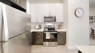 a kitchen with stainless steel appliances and a clock on the wall at Bridge at Speyside Apartments, Austin, TX, 78754