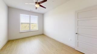 A room with a ceiling fan and a window with blinds. at ThreeTwenty at the Vybe Apartments, Kyle, 78640